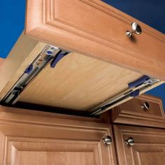 a kitchen cabinet door is open to show the drawer and pull out handles on it