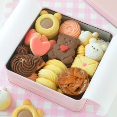 a pink box filled with lots of different types of cookies