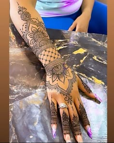 a woman's hand with henna tattoos on it