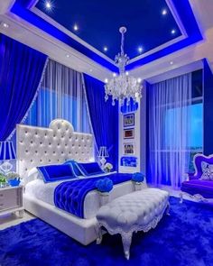 a blue and white bedroom with a chandelier hanging from the ceiling