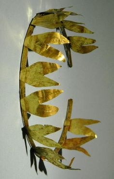 a metal object with gold leaves on it