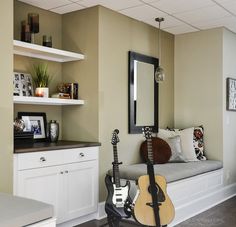 a living room with a couch, guitar and mirror