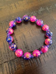 Who doesn't love a pop of color? And that's exactly what you'll get with this brightly colored bracelet featuring 10mm round glass beads in pink and purple with yellow and orange splatters and purple/blue seed beads. Bracelet is approximately 7.5 to 8 inches and is made with clear stretchy elastic and should fit most wrists. If you need a smaller or larger size, message me and I'll see what I can do! All bracelets are sold AS IS. You will receive the one shown in the picture. Please be careful with the bracelet as it is not indestructible. Avoid water, gels, lotions, soaps, etc. Not intended for children. Please note that beads are a choking hazard and I am not liable if they are ingested. Colorful Stretch Bracelet With Large Round Beads, Colorful Beaded Purple Bracelets, Purple Stretch Bracelet With Large Round Beads, Purple Colorful Beaded Bracelets, Purple Stretch Bracelet With Colorful Beads, Purple Beaded Bracelets With Large Beads, Purple Bracelets With Large Beads, Purple Beaded Bracelet With Large Round Beads, Purple Bracelets With Colorful Round Beads