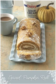 a loaf of pumpkin roll sitting on top of a table next to a cup of coffee