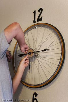 a man is working on a bicycle wheel clock