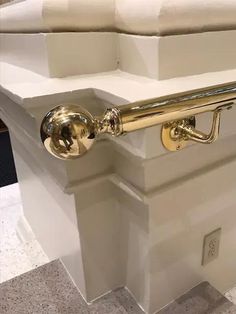 a close up of a door handle on the side of a white box with gold handles