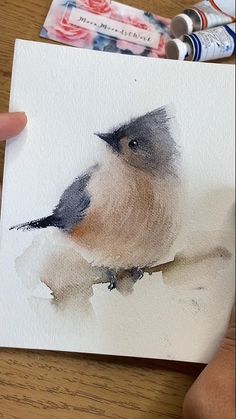 a small bird sitting on top of a piece of paper