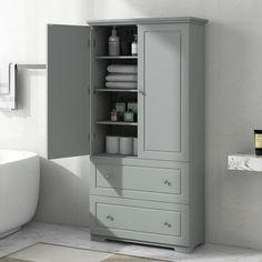 a bathroom with a white bath tub and gray cabinet in the corner next to it