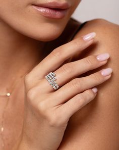 a close up of a woman wearing a ring with diamonds on her finger and shoulder