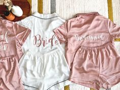 two pink and white bridesmaid pajamas sitting next to each other on a bed