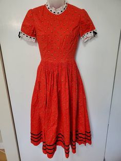 "Amazing handmade vintage dress from the 60's/70's! No labels.gr Red floral fabric with lace accents and velvet ribbon.  Maxi length. Zipper in back. Smocking on Waist- some is coming undone. In Great Vintage Condition - rip in underarm has been repaired. Measurements: Bust: 34\" Waist: 26\" Hips: free Shoulders: 14\" Length: 46\"" Fitted Red Smock Dress, Vintage Red Dress With Lace Trim, Red Vintage Dress With Lace Trim, Vintage Smocked Fitted Dress, Fitted Smock Vintage Dress, Fitted Vintage Smock Dress, Vintage Short Sleeve Smock Dress, Vintage Smock Dress With Short Sleeves, Fitted Cotton Prairie Dress With Smocked Bodice