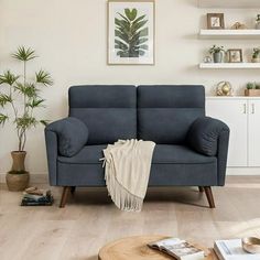 a living room with a blue couch and wooden coffee table in front of the window