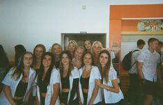 a group of young women standing next to each other in front of an open door