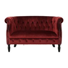 a red velvet couch with studded legs and buttons on the arm, against a white background