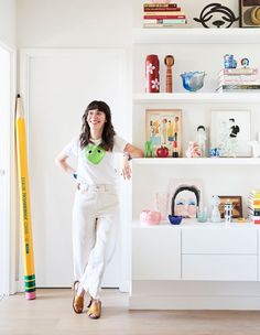 a woman standing in front of a book shelf