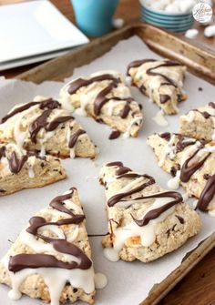 cookies with chocolate drizzled on them sitting on a baking sheet, ready to be eaten