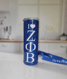 a blue can with the word i love zeeba printed on it next to a measuring tape