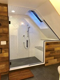 an attic bathroom with wood paneling and white walls