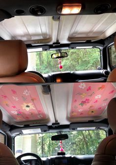 the interior of a vehicle with pink and white flowers painted on it's ceiling