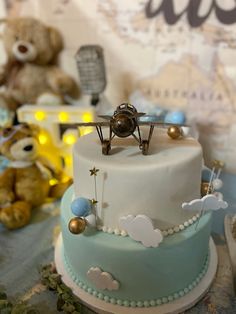 there is a small airplane on top of the cake, and two teddy bears are in the background