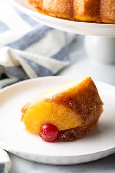 a piece of pineapple upside down cake on a plate next to a bundt cake