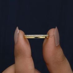 a woman's hand holding a diamond ring in front of her face and the other hand