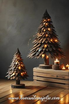 two wooden christmas trees sitting on top of a wooden table next to each other with lit candles