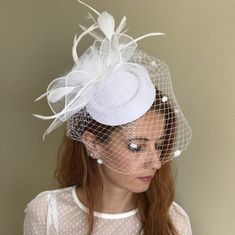 This is a handcrafted felt wedding fascinator hat, with flower looking tulle, delicate feathers, and birdcage veil. The color is white, goes with common wedding dress colors. Burgundy color is also available for this listing. It is made in a standard one-size, and it has a hair clip under it for easy wearing on any hair style. This model and other models are available in various colors, check them out from here: https://www.etsy.com/shop/ArtisanTulipBridal?section_id=44269044 Perfect to accentua Fitted Mini Hat With Feathers For Wedding, Wedding Mini Hat With Feather Trim For Kentucky Derby, Kentucky Derby Wedding Mini Hat With Feather Trim, Feathered Top Hat For Kentucky Derby Wedding, Spring Wedding Mini Hat With Feather Trim, Feathered Fascinator For Wedding At Royal Ascot, Feather Fascinator For Wedding And Royal Ascot, Wedding Fascinator With Feather Trim And Short Brim, Wedding Costume Hat With Feathers