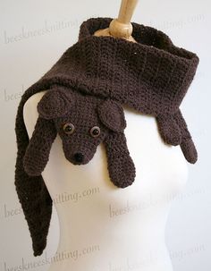 a crocheted dog hat on top of a mannequin's head