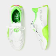 a pair of white shoes with neon green accents on the soles and laces