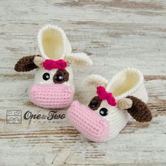 two crocheted cow slippers with bows on them