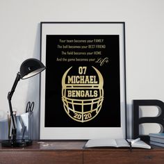 a framed football poster on a desk next to a lamp