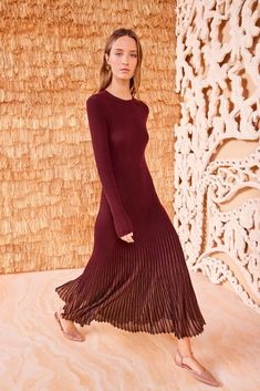 A bestselling silhouette, the Mila Dress is made from our sunburst rib knit with shimmering lurex between each rib, amplified at the skirt. This long-sleeve, dark red dress has a classic crewneck, is designed for a close fit, and unfurls to a flared midi hem with mesmeric movement at every step. Composition: 58% Viscose, 42% Polyester Mila Dress, Dark Red Dress, Nyc Boutiques, Dark Red Dresses, Knit Denim, Denim Accessories, Sleeved Dress, Knitted Coat, Knit Midi