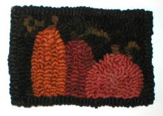 an orange and black knitted dishcloth with two pomegranates