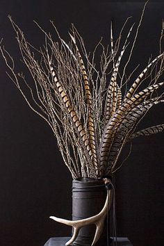 a vase filled with dried plants on top of a table