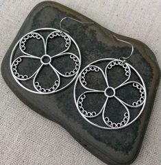 "These are so unique and cool! Big silver flower hoop earrings. They are modern and whimsical. Eye catching and versatile. Dress them up or down. The earrings measure 1 3/8\" long by 1 3/8\" wide and are made from plated silver. They hang from simple silver ear wire hooks. Overall drop length is 1 1/2\". I have a matching necklace in my shop if you would like the whole set. Here is a direct link Thanks for stopping by! Please take a moment and visit the rest of my Etsy store. I have many more un Sterling Silver Flower Hoop Earrings For Pierced Ears, Silver Metal Flower Hoop Earrings, Silver Flower-shaped Metal Hoop Earrings, Sterling Silver Flower Hoop Earrings, Silver Flower Hoop Earrings, Silver Nickel-free Flower Shaped Hoop Earrings, Silver Round Earrings For Spring, Round Metal Flower Earrings With Ear Wire, Spring Silver Metal Hoop Earrings