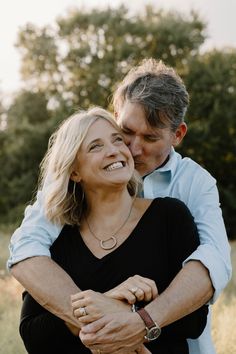 a man and woman hugging each other in a field