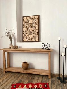 a wooden table sitting on top of a hard wood floor next to a vase filled with flowers