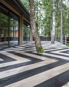 an empty walkway in front of a building surrounded by trees