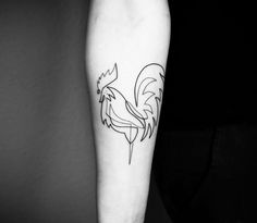 a black and white photo of a rooster tattoo on the right arm, with an outline of a bird