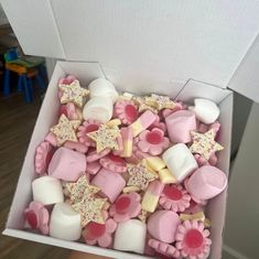 a box filled with pink and white cookies