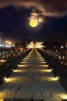 an empty cemetery at night with the moon in the sky