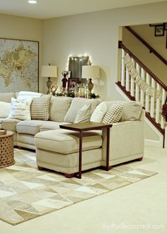 a living room filled with furniture and a stair case in front of a map on the wall