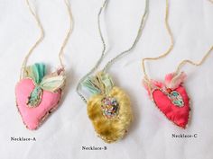 three necklaces with different designs on them