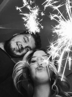 black and white photograph of two people with sparklers