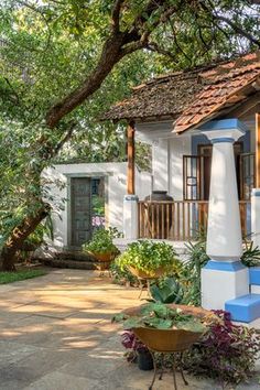 a small white house with blue trim on the porch