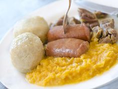 a white plate topped with meat and mashed potatoes