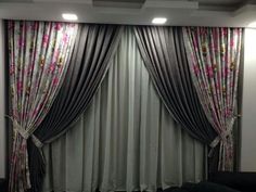 the living room is decorated in black and white colors with pink flowers on the drapes