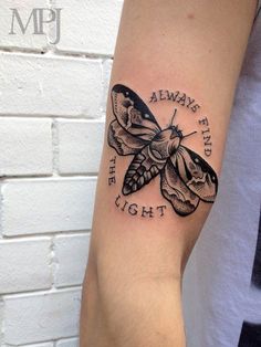 a black and white tattoo on the arm of a woman with a butterfly in it