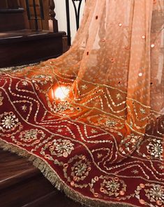 a red and gold sari on top of a stair case